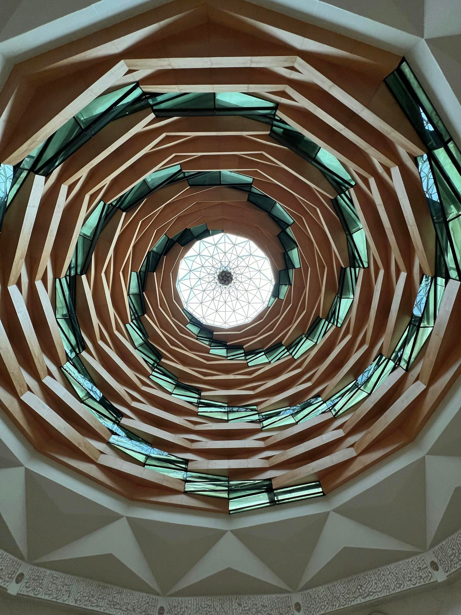 Stunning upward view of a geometric spiral ceiling, showcasing intricate architectural design.